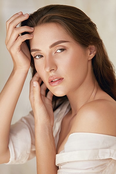 Model with flowing hair in white attire.