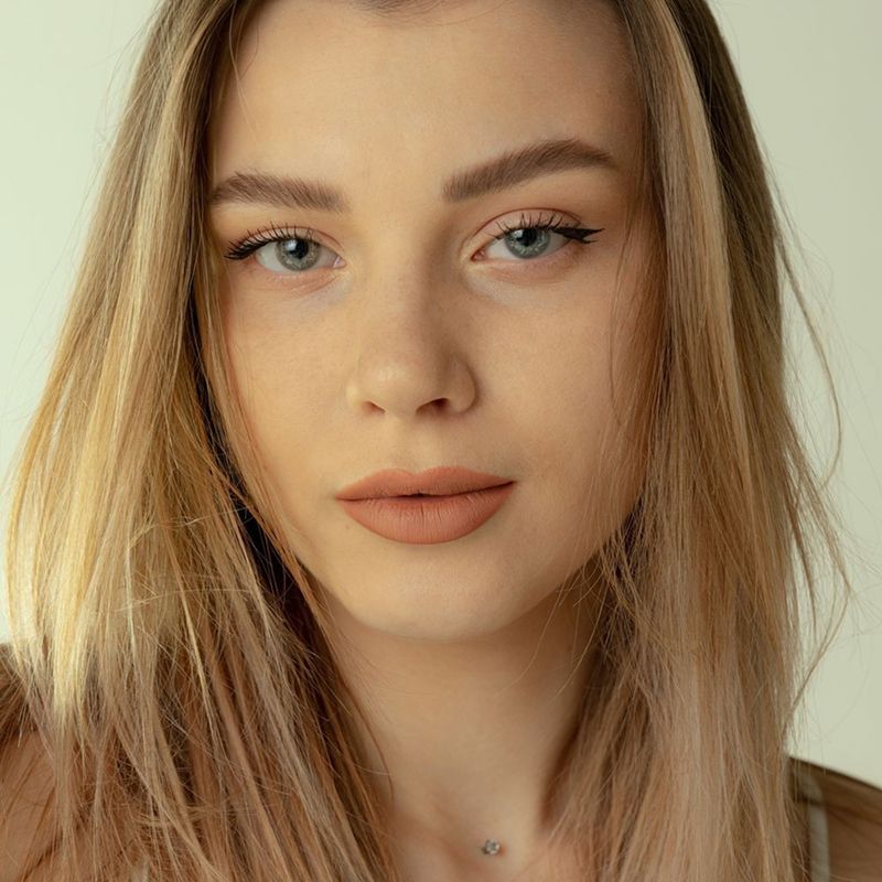 Portrait of a woman with light hair and makeup.