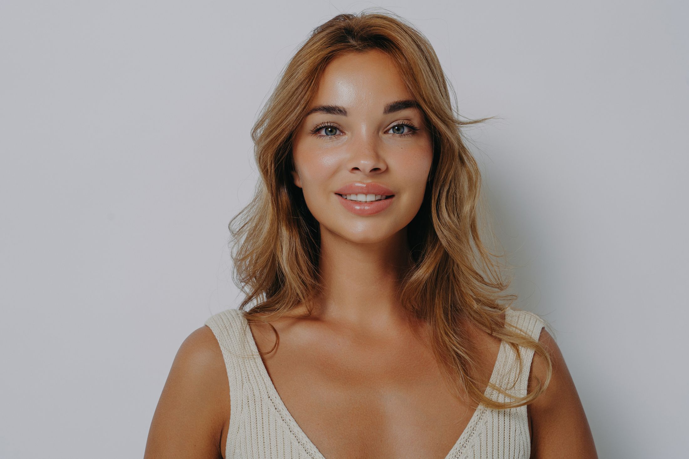 Smiling woman with long wavy hair.